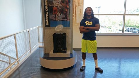Chawntez Moss poses by the 1976 National Championship trophy at Pitt's football practice facility. Steve Rotstein | Contributing Editor