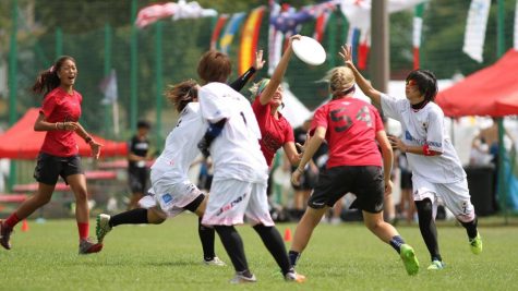 Schreiber, center, with disc, lays out for a disc during the USA U-20 team's game against Japan in Wroclaw, Poland this August. Courtesy of Katie Schreiber