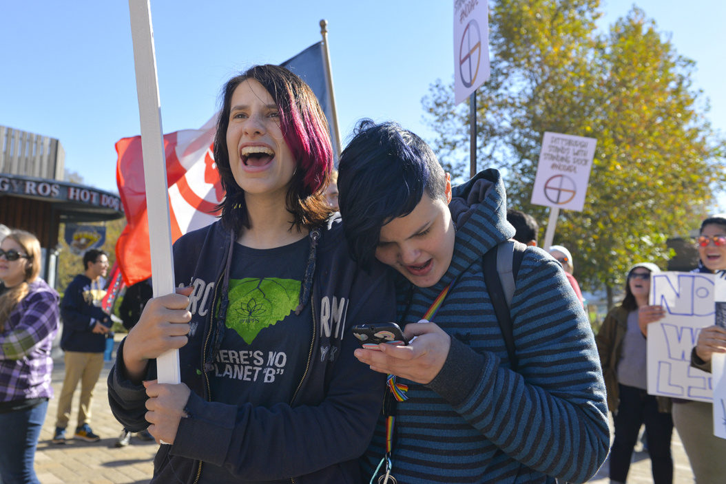 Jimmy Coblin, (left) in high school, and Riley Duncan, (right) a Job Corps member, chant, "What do we want? Clean water. When do we want it? Now," against the Dakota Access Pipeline in Schenley Plaza late Saturday morning. Stephen Caruso | Senior Staff Photographer