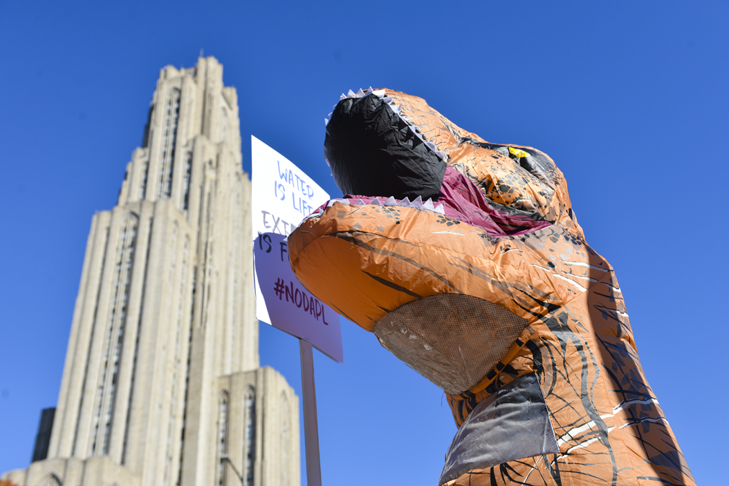 One protester, dressed as a dinosaur, held a sign proclaiming, "Water is life, extinction is forever." Stephen Caruso | Senior Staff Photographer