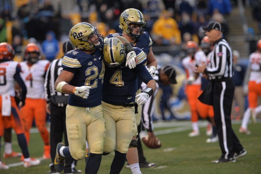 Pitt RB James Conner (24) hugs QB Nathan Peterman (4) after Peterman's 13-yard touchdown run late in the first half. Steve Rotstein | Contributing Editor