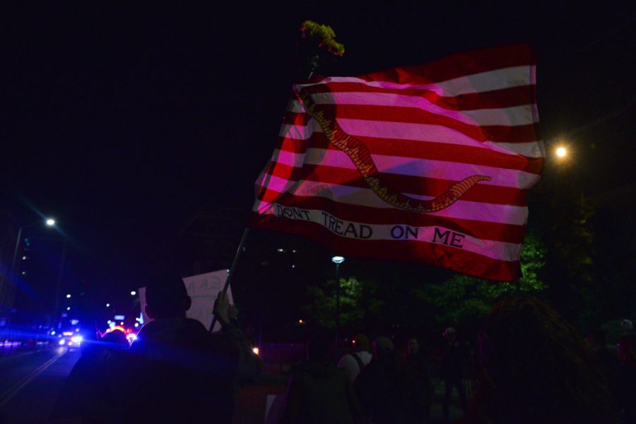 With cop cars leading the way to create a moving blockade, the protesters fiollowed. Rob Helwis, a part time student at Pitt, waved a "don't tread on me" flag as he marched. "This flag has been around a lot longer than the Tea Party," Helwis said. Stephen Caruso | Online Visual Editor