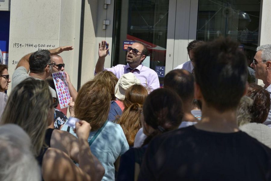 A bank employee at a branch of Eurobank in central Athens tries to calm the tempers of account holders having to queue and slowly, selectively be allowed inside the bank on Wednesday, July 8, 2015. (Chris Stowers/Zuma Press/TNS)