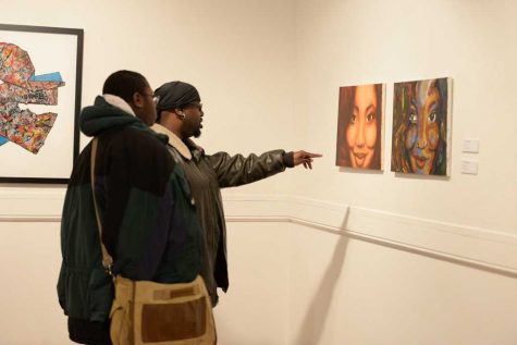 Guests of the opening reception for “Exposure: Black Voices in the Arts” interact with the art. Meghan Sunners | Senior Staff Photographer