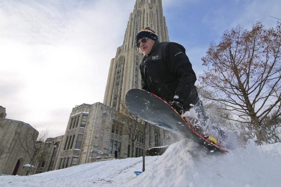 Antonio Narducci launches off a snow bank outside of the Cathedral of Learning Saturday afternoon. Theo Schwarz | Senior Staff Photographer