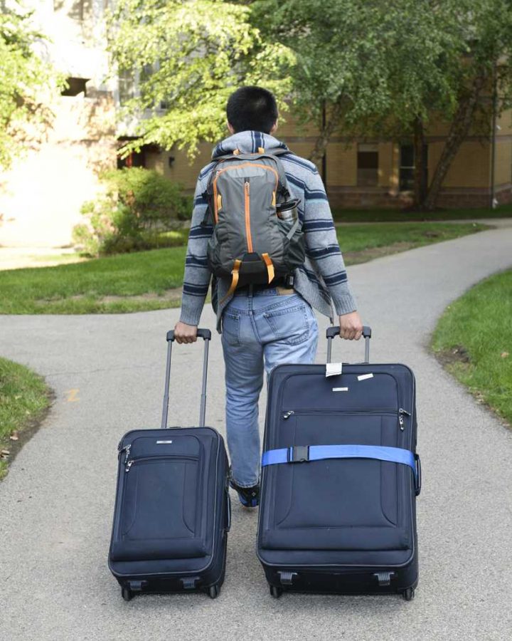 Andrew Liu, from Portland, Ore., fresh from the plane, rolls his bags towards his new home. Stephen Caruso / Senior Staff Photographer