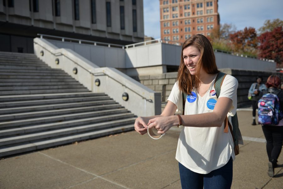 Junior politics and philosophy major Kait Pendrak hands out voting stickers to students on campus. Katie Krater | Staff Photographer