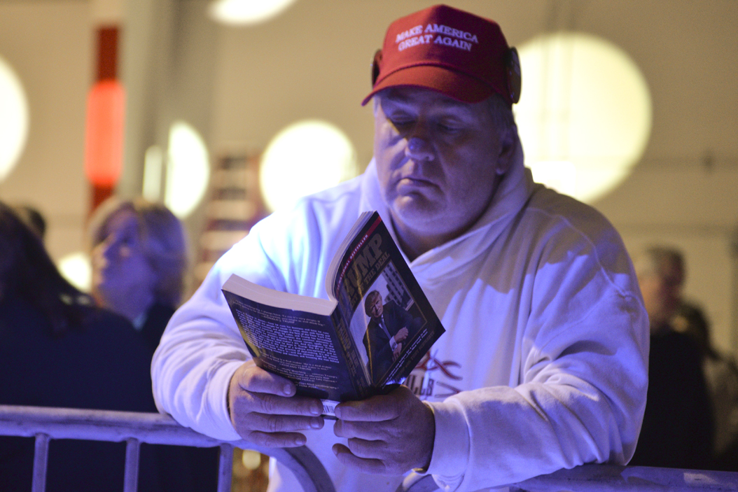 A supporter reads Trump's book "The Art of the Deal" before the candidate arrived. John Hamilton | Senior Staff Photographer
