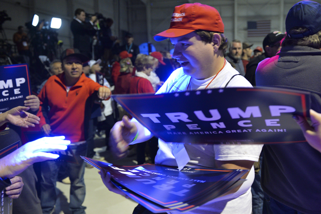 A Trump volunteer hands out signs. John Hamilton | Senior Staff Photographer