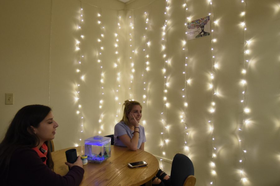 Abrams and Miranda sit nearby a wall lined by string lights. Li Yi | Staff Photographer