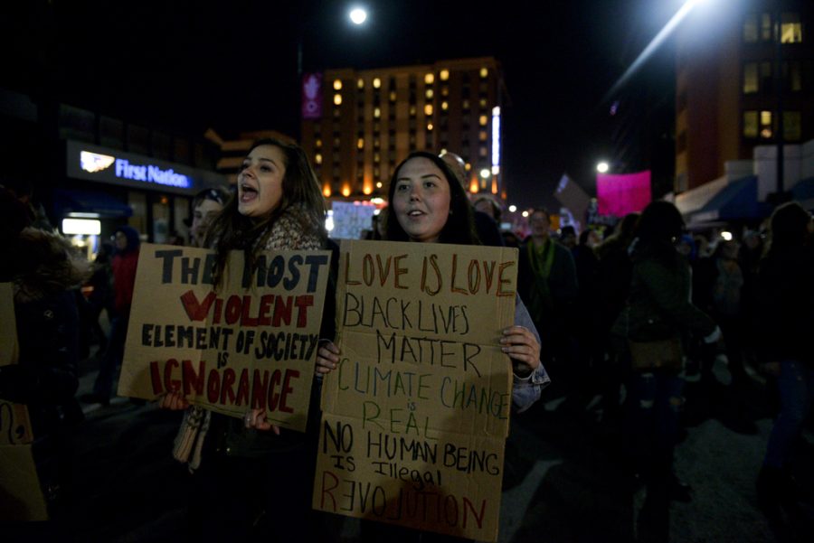 Allison Beck, left, and Sam Cochran, right, march up Forbes Avenue with the protest, returning to Oakland after an extended vigil on the Birmingham Bridge. Stephen Caruso | Online Visual Editor