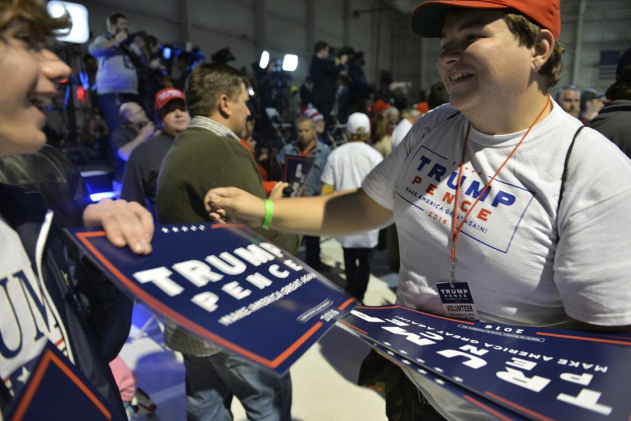 A Trump supporter hands out signs at a rally at Pittsburgh International Airport in Moon, Pa. on Nov. 6, 2016. John Hamilton | Senior Staff Photographer