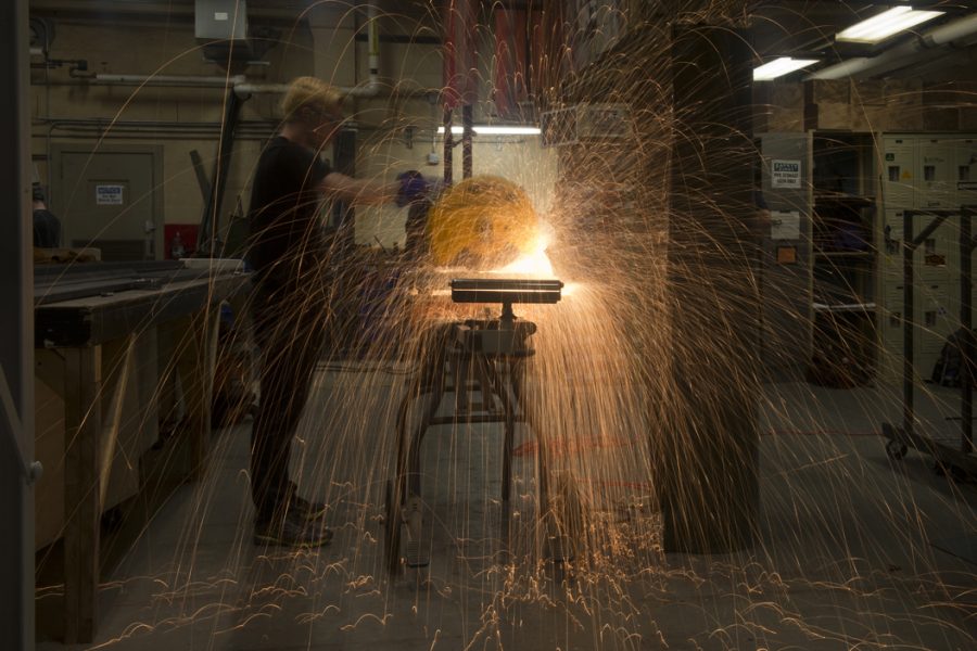 Sparks fly as Sean Gallagher cuts a metal support beam for a set piece. Gallagher and everyone else in the shop wore ear plugs during the cutting.