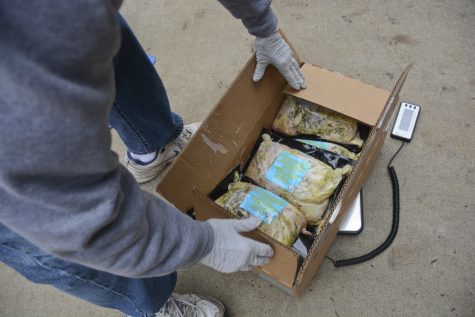 A volunteeer at South West Meals on Wheels grabs a box of food from Trader Joe's brought to them by 412 Food Rescue. Stephen Caruso | Online Visual Editor
