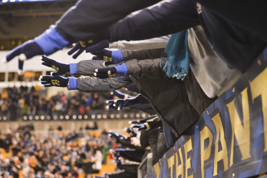 Pitt fans reaching out during the singing of Sweet Caroline after the third quarter in Pitts 56-14 win against Duke. John Hamilton | Senior Staff Photographer