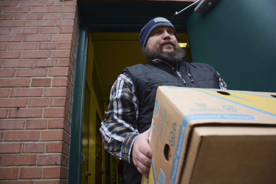Scott Marshall, 41, carries a box of food to 412 Food Rescues truck in Carnegie. Stephen Caruso | Online Visual Editor