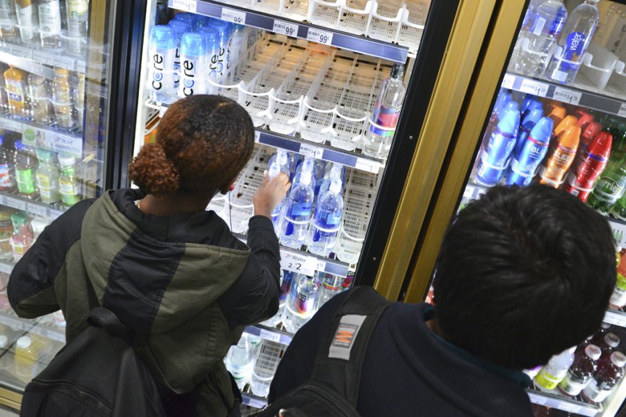 Ashley Brown, a junior neuroscience major, reaches into a cooler to buy water for her and her sorority sisters after a water alert was issued by the city of Pittsburgh on Tuesday evening. Stephen Caruso | Online Visual Editor
