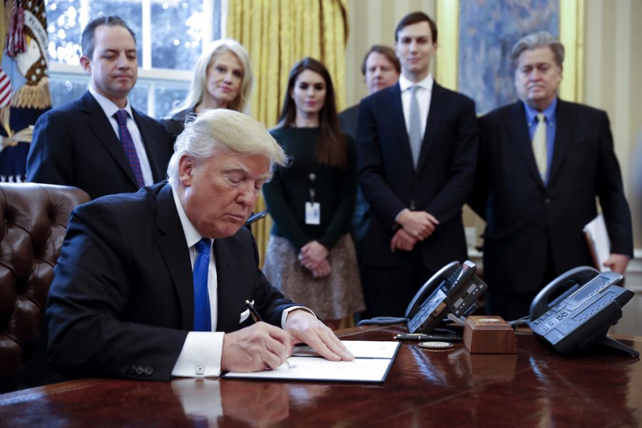 US President Donald Trump, with White House chief of staff Reince Pribus, from left, counselor to the President Kellyanne Conway, White House Communications Director Hope Hicks, Senior Advisor Jared Kushner and Senior Counselor Stephen Bannon, signs one of five executive orders related to the oil pipeline industry in the oval office of the White House Tuesday, Jan. 24, 2017 in Washington, D.C. President Trump has a full day of meetings including one with Senate Majority Leader Mitch McConnell and another with the full Senate leadership. (Pool/Abaca Press/TNS)
