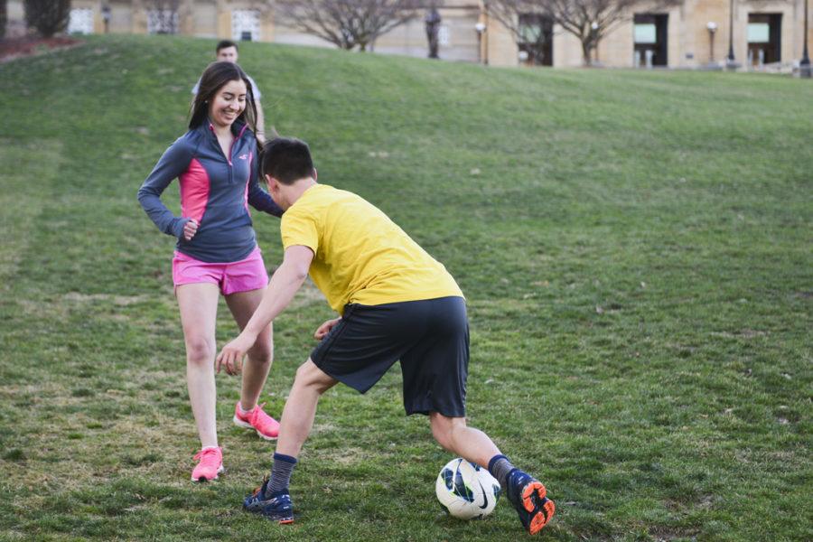 Taking advantage of the warm weather, first-years Sheridan Feck and Kiel Hillock play soccer on the Soldiers and Sailors Memorial lawn on Feb. 6. Anna Bongardino | Staff Photographer