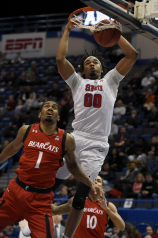 SMU Mustangs forward Ben Moore (0) dunks over Cincinnati Bearcats guard Jacob Evans (1) and guard Troy Caupain (10) during the first half of the 2017 AAC Championship on Sunday, March 12, 2017 at the XL Center in Hartford, Connecticut. (John Woike/Hartford Courant/TNS)