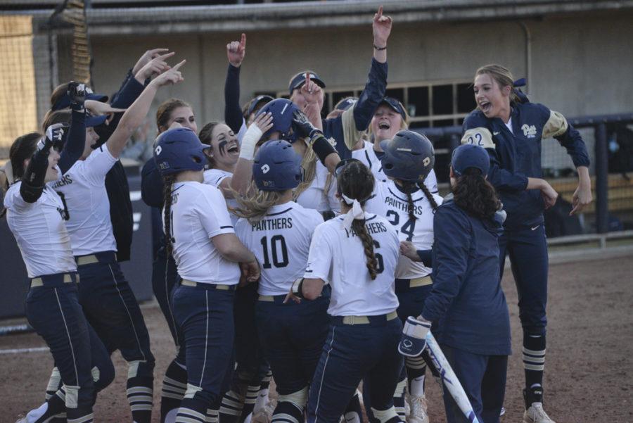 The Pitt softball team greets sophomore Gabrielle Fredericks at home plate after her pinch-hit two-run home run in a 7-1 win over Penn State. Kyleen Considine | Staff Photographer