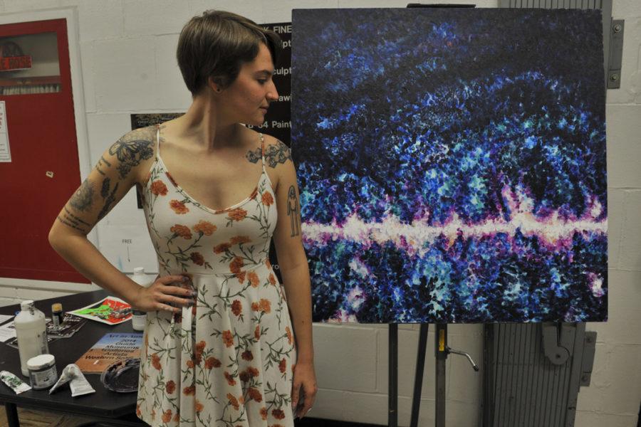 Sarah Thornton, a senior studio arts major, looks at one of her pieces, a baby picture of the universe, inspired by her cooperation with physics professor Andrew Zentner. Stephen Caruso | Assistant Visual Editor 