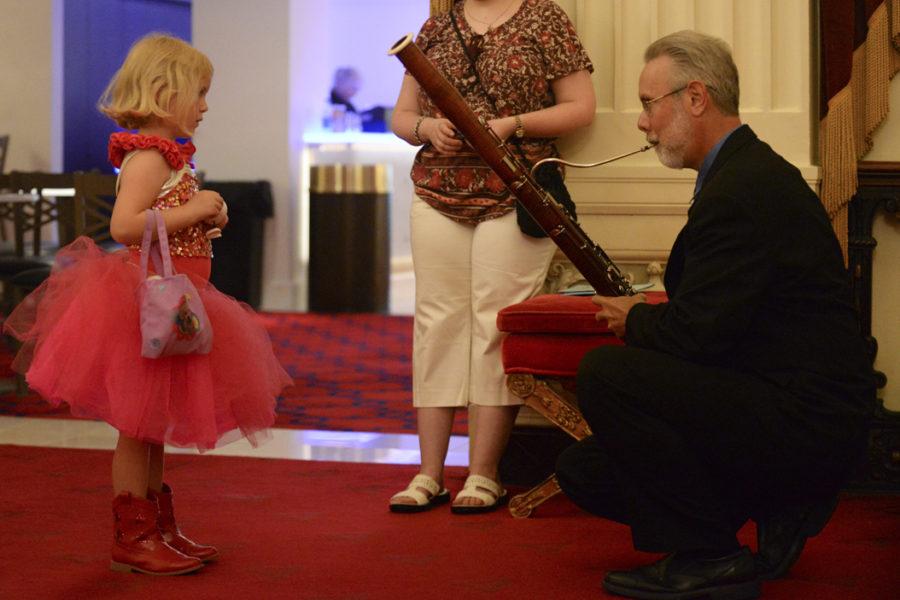 James Rodgers, a contrabassoonist for the Pittsburgh Symphony Orchestra, shows a child how his instrument is played in the Grand Tier Foyer of Heinz Hall before the sensory-friendly performance on Saturday. (Photo by Anna Bongardino | Visual Editor)
