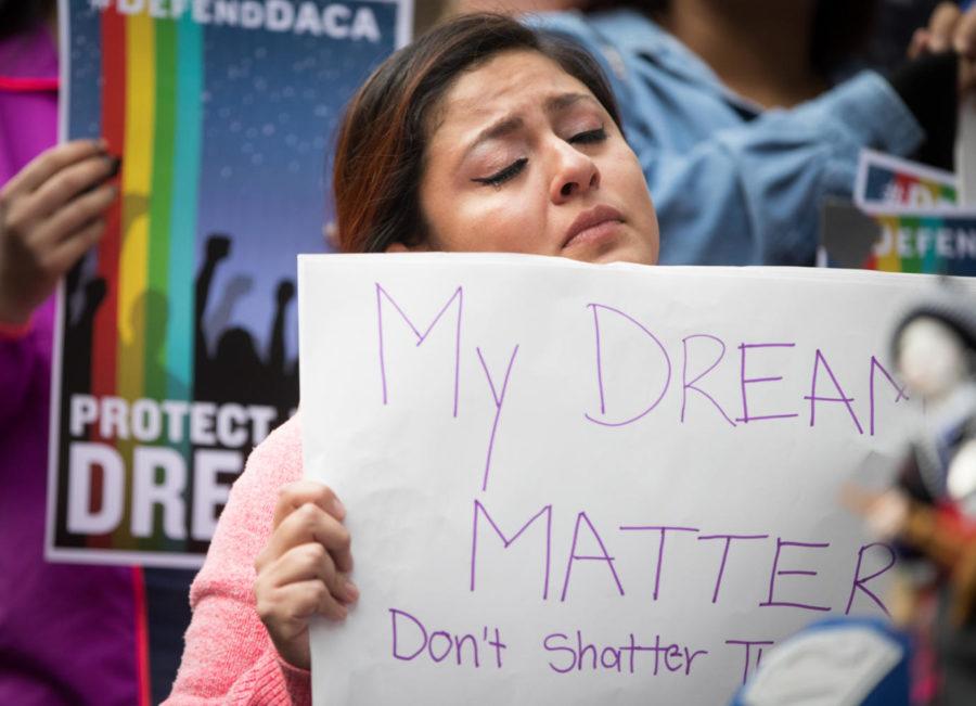 Evelin Hernandez holds a sign in front of the Hennepin County Jail in Minneapolis after President Donald Trump announced his plans to rescind DACA on Tuesday. (Photo by Schneider/Minneapolis Star Tribune/TNS)