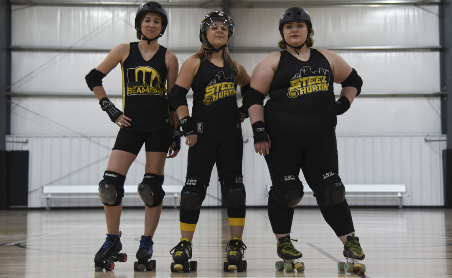 (From left) Alyssa Quintanilla, Jamie Fargo and Alivia Martin stand in the middle of the flat rink at the Pittsburgh Indoor Sports Arena, where they practice and hold games. (Photo by Anna Bongardino | Assistant Visual Editor)