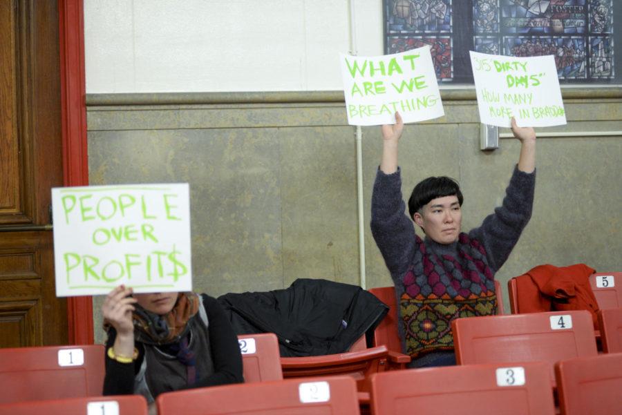 Ginger Brooks Takahashi (right) protested during the Lawrenceville Steel Foundry Public Hearing Monday night at Arsenal Middle School. (Photo by Aaron Schoen | Staff Photographer)
