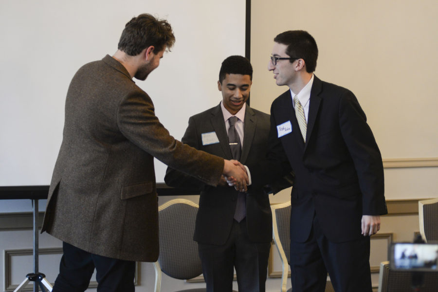 Andrew Dow (left), the host of Pitt Tonight, greets candidates Matt Jones and Noah Rubin (right) at the 2018 Meet the Candidates event in the William Pitt Union dining room. (Photo by Sarah Cutshall | Staff Photographer)