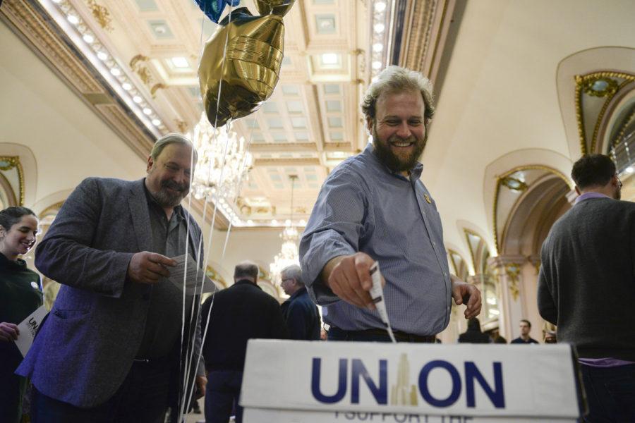 Tyler Bickford, a professor in the English department, drops one of the first union cards at a kick-off event held by Pitt faculty union organizers in the William Pitt Union Ballroom in January 2018.