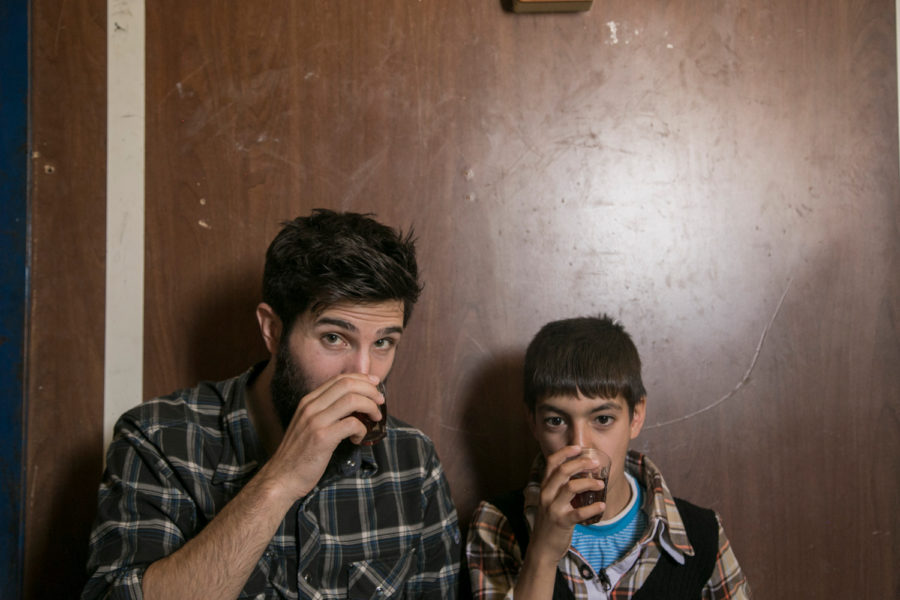 Zach Ingrasci, co-director of Salam Neighbor, shares tea with Raouf, one of the subjects of the documentary. (Image via Wikimedia Commons)
