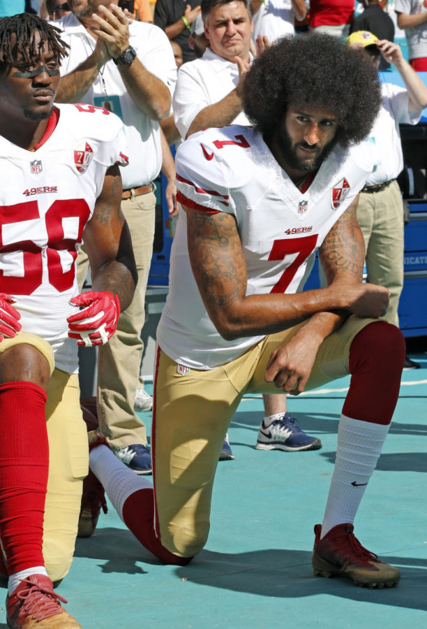 San Francisco 49ers outside linebacker Eli Harold (58) and quarterback Colin Kaepernick (7) take a knee during the national anthem before a game against the Miami Dolphins on Sunday, Nov. 27, 2016 at Hard Rock Stadium in Miami Gardens, Fla. (Al Diaz/Miami Herald/TNS)