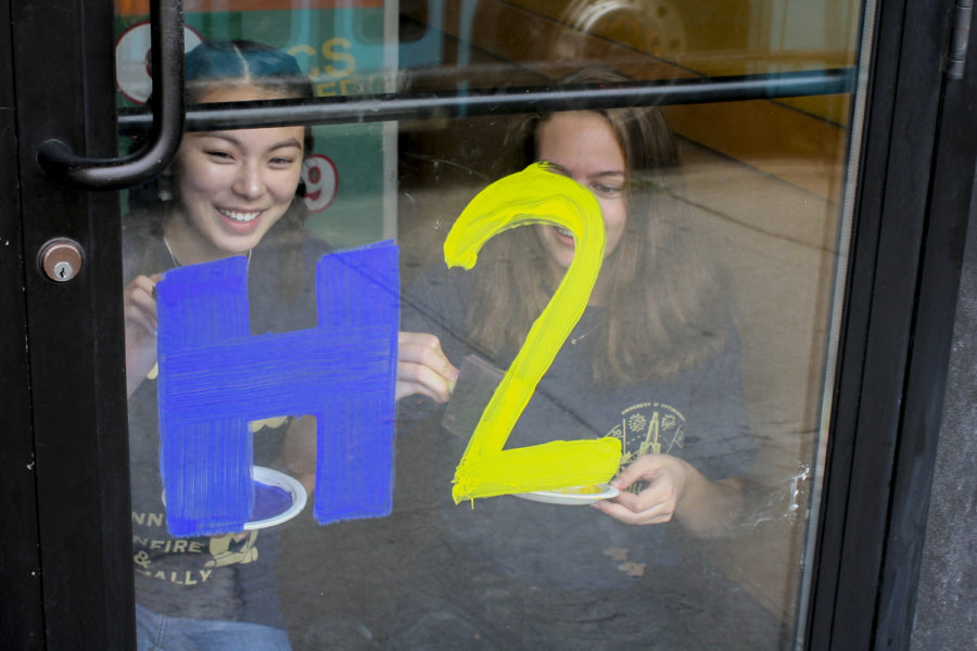 First-years Lily McIntire (left) and Alden Paine paint “H2P” on Popeye’s door Monday for Paint the Town — an event hosted by Pitt Student Alumni Association — in preparation for Homecoming.
