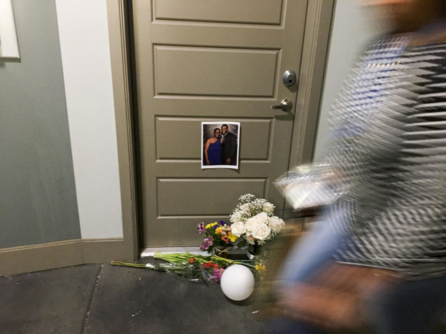 A resident passes flowers at the front door of Botham Shem Jean, who Dallas police say was shot Thursday by Amber Guyger, an off-duty police officer who mistakenly thought her apartment was his, as photographed on Monday, Sept. 10, 2018 at the South Side Flats in Dallas, Texas. Guyger was in uniform. (Shaban Athuman/Dallas Morning News/TNS)
