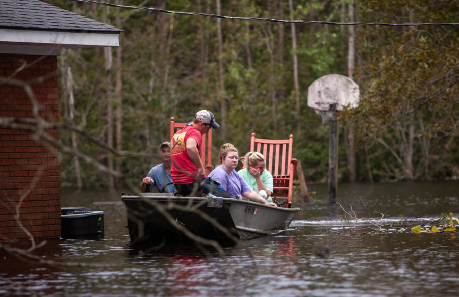 From left, Mike Haddock, 48, Justin Humphrey, 24, Katlyn Humphrey, 19, and Michelle Haddock, 45, remove possessions from the Haddocks flooded home using a jon boat on Monday, Sept. 17, 2018 in Trenton, N.C. following Hurricane Florence. (Travis Long/Raleigh News & Observer/TNS)