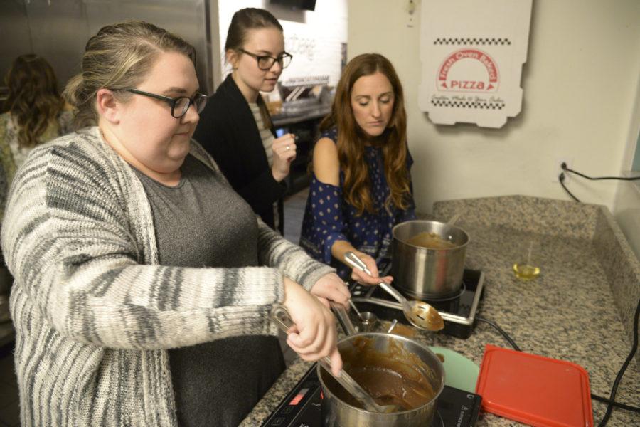 Missy Chafin (left) of Ross Township and Margaret Mullinary (right) of West View spoon their apple butter onto a plate to taste it before taking it off the burner. 