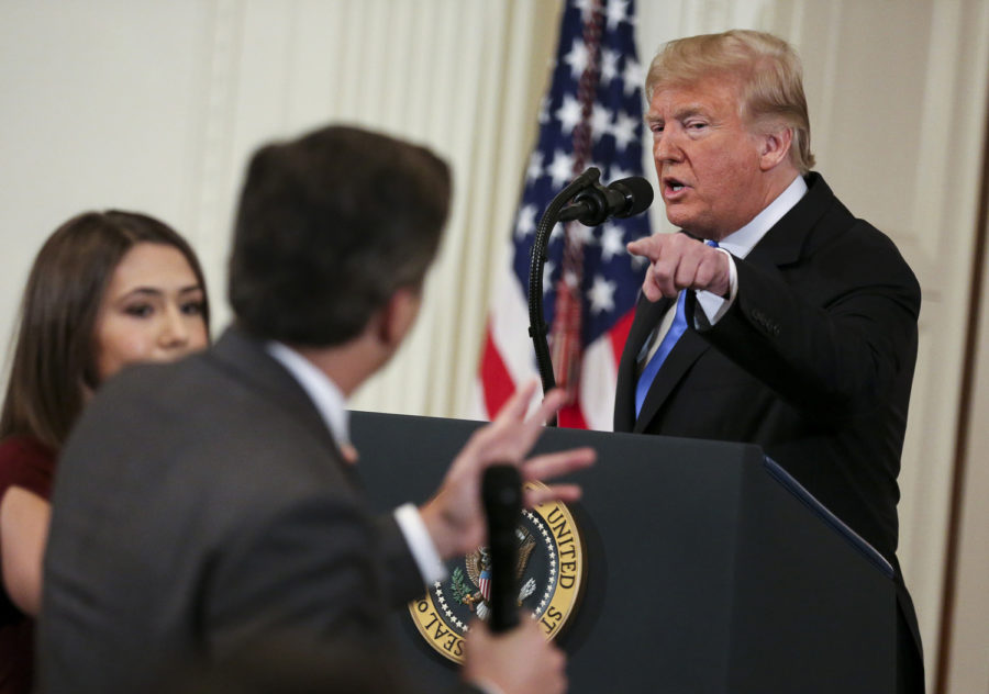 A White House staff member (left) tries to take away the microphone from CNN White House correspondent Jim Acosta during an exchange with President Donald Trump on Nov. 7 in Washington, D.C. 