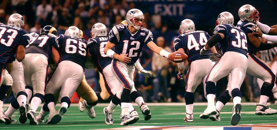 New England Patriots quarterback Tom Brady (12) hands the ball off to Antowain Smith (32) during Super Bowl XXXVI at the Louisiana Superdome.
