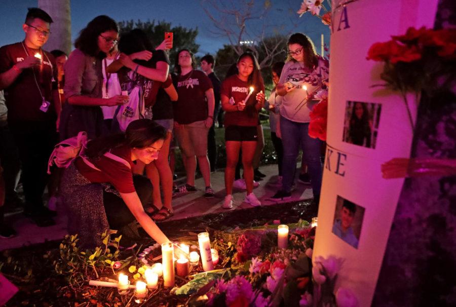 People light candles for a makeshift memorial after an interfaith ceremony at Pine Trails Park in Parkland, Fla., to remember the 17 victims killed last year at Marjory Stoneman Douglas High School, on Thursday, Feb. 14, 2019. 