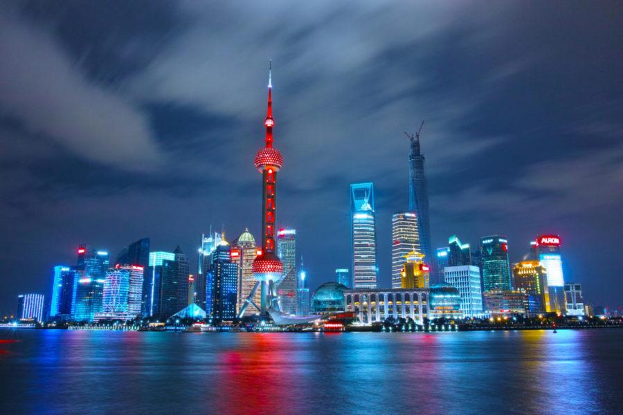 The bright lights of Shanghais skyline are photographed at night.