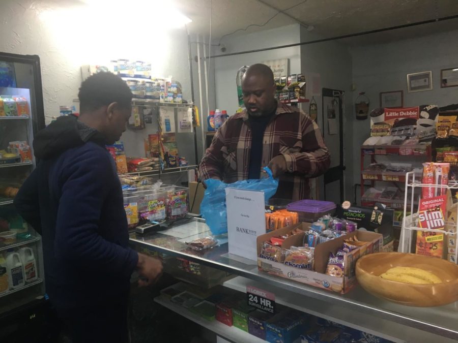 Carl Lewis bags a customers purchase at his corner store. 