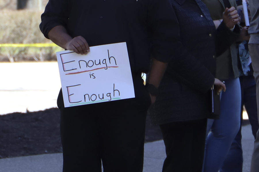 A demonstrator holds a sign reading “enough is enough” at the die-in demonstration organized by Black Action Society on Wednesday.