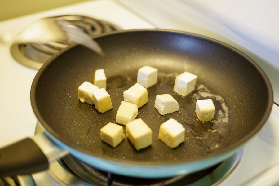 Tofu cooking in a pan.
