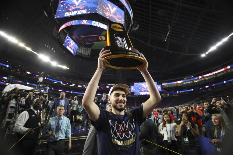 Virginia Cavaliers guard Ty Jerome hoists the championship trophy aloft as he walks off the court on Monday at U.S. Bank Stadium in Minneapolis. Virginia defeated Texas Tech 85-77 in overtime to win the NCAA Division I Mens Basketball Championship.