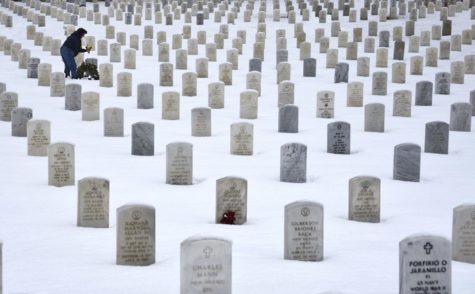 SANTA FE, NEW MEXICO - JANUARY 11, 2019: A woman places flowers on the grave of a loved one at the Santa Fe National Cemetery in Santa Fe, New Mexico, which is administered by the United States Department of Veterans Affairs. (Photo by Robert Alexander/Getty Images)