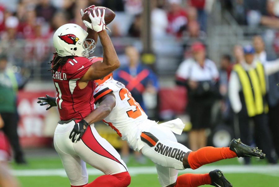 Arizona Cardinals wide receiver Larry Fitzgerald hauls in a first-down reception as he is hit by Cleveland Browns defensive back T.J. Carrie in the first quarter, Dec. 15, 2019, at State Farm Stadium.