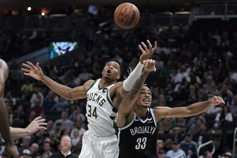 Milwaukee Bucks' Giannis Antetokounmpo (34) and Brooklyn Nets' Nicolas Claxton (33) reach for the ball at Fiserv Forum in Milwaukee on Tuesday. 