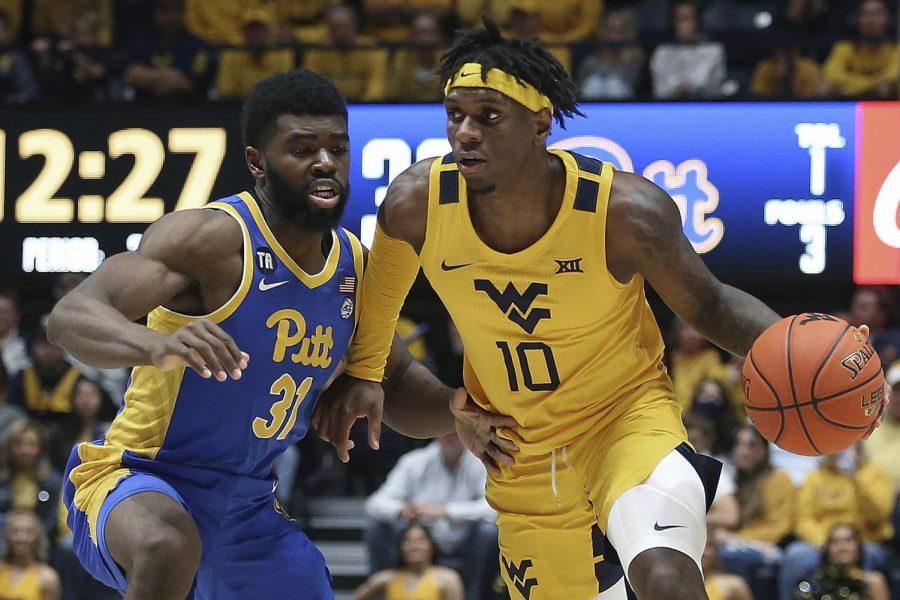 West Virginia guard Malik Curry (10) works the ball as Pittsburgh guard Onyebuchi Ezeakudo (31) defends during the second half of an NCAA college basketball game in Morgantown, W.Va., Friday, Nov. 12, 2021. 